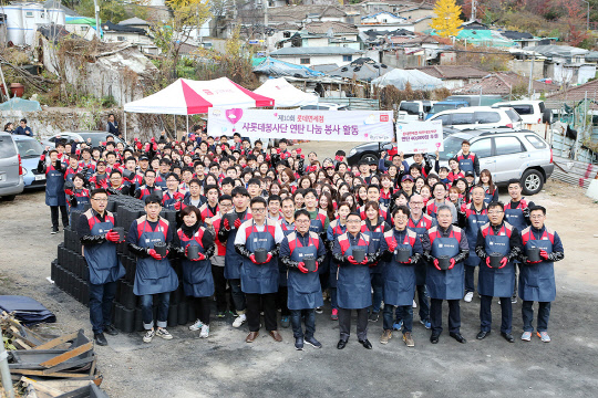 롯데면세점 샤롯데봉사단과 협력사원 200여 명은 지난 10일 서울 중계본동 백사마을 연탄은행에 연탄 4만장을 전달했다. 이날 현장에서 회사 임직원들이 연탄을 들고 기념촬영을 하고 있다.  롯데면세점 제공